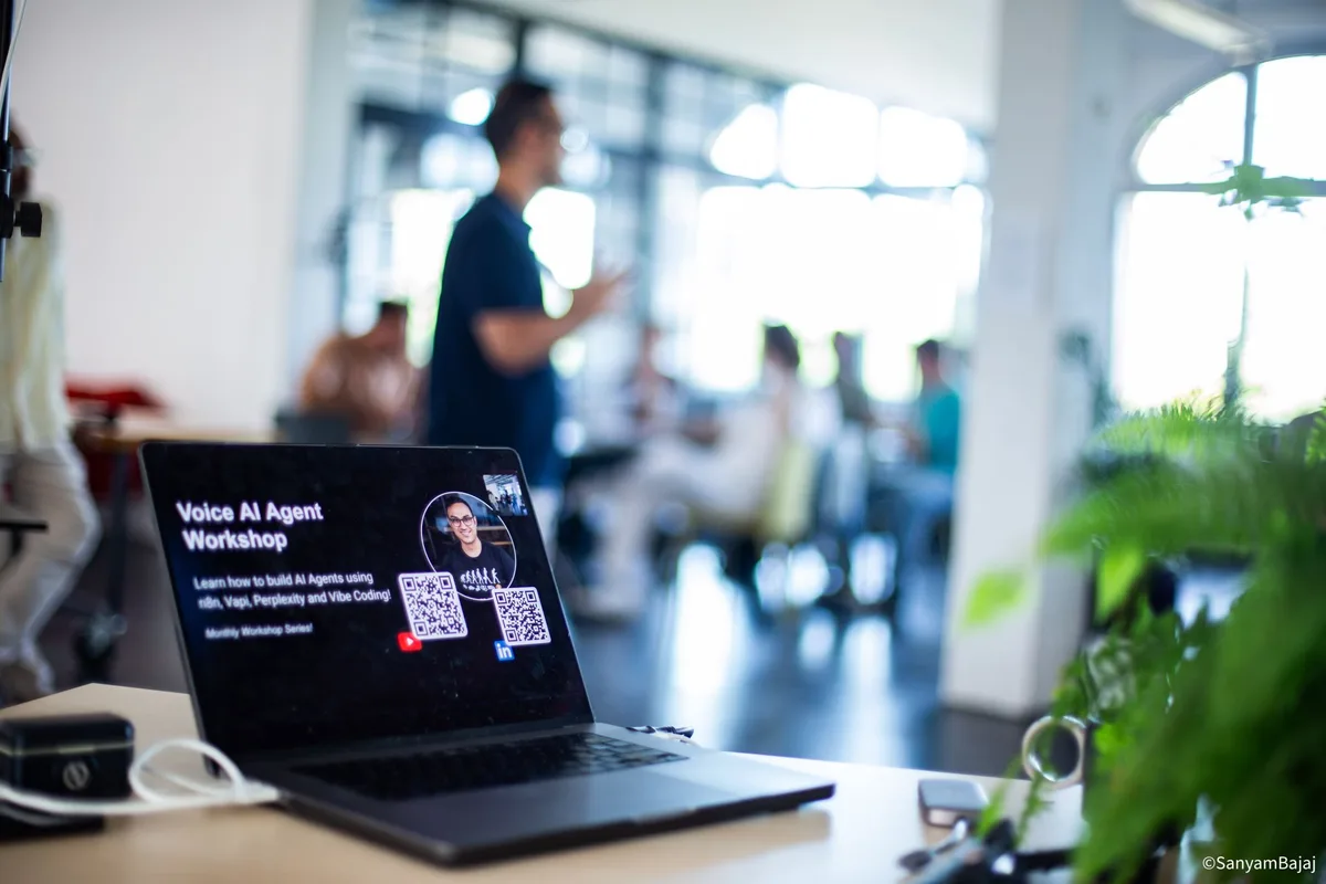 Voice AI workshop materials on a laptop with a teaching session in the background